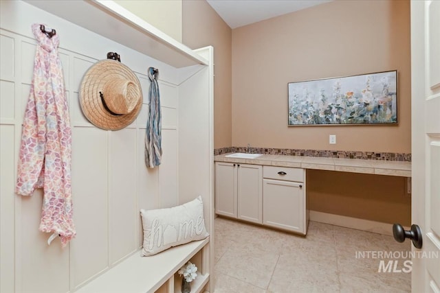 mudroom with light tile patterned floors and a sink
