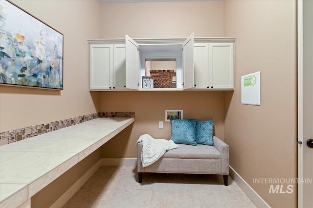 sitting room with baseboards and light tile patterned flooring