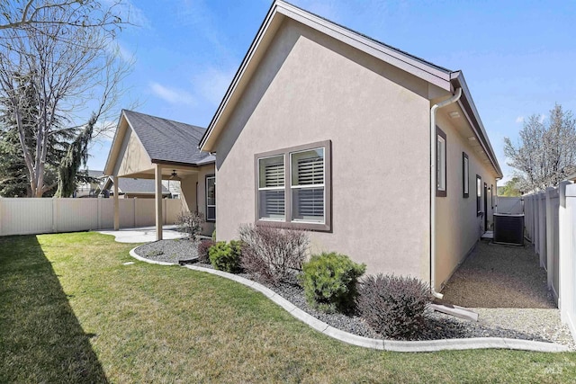 view of side of home featuring central air condition unit, a fenced backyard, stucco siding, a lawn, and a patio