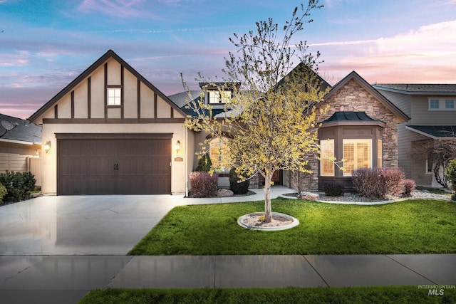 view of front facade with stone siding, a garage, concrete driveway, stucco siding, and a front lawn