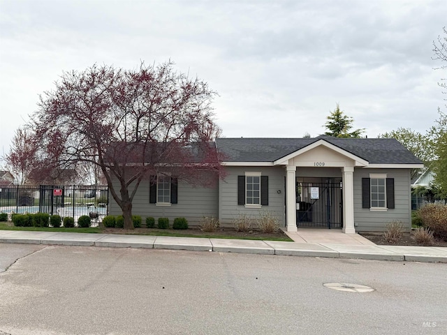 single story home with fence and roof with shingles