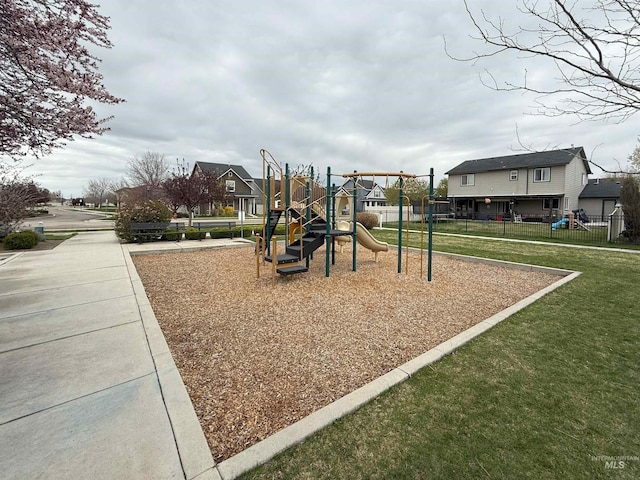 communal playground with a residential view, fence, and a lawn