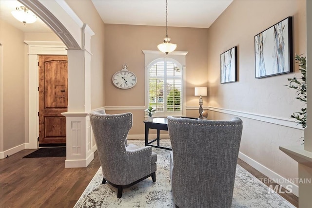 dining room featuring baseboards, ornate columns, arched walkways, and dark wood-style floors