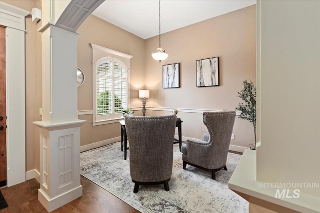 sitting room with ornate columns, baseboards, and wood finished floors