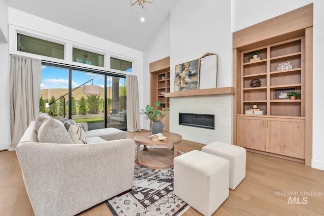 7060 E La Cuesta St, Boise, ID 83716 - living area featuring high vaulted ceiling, a glass covered fireplace, built in shelves, wood finished floors, and recessed lighting