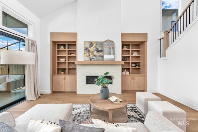 7060 E La Cuesta St, Boise, ID 83716 - living area featuring high vaulted ceiling, baseboards, a brick fireplace, wood finished floors, and stairs
