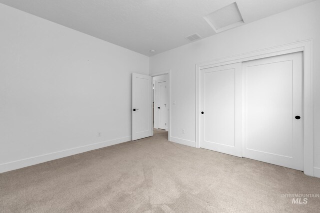 7060 E La Cuesta St, Boise, ID 83716 - unfurnished bedroom featuring attic access, light colored carpet, a closet, and baseboards