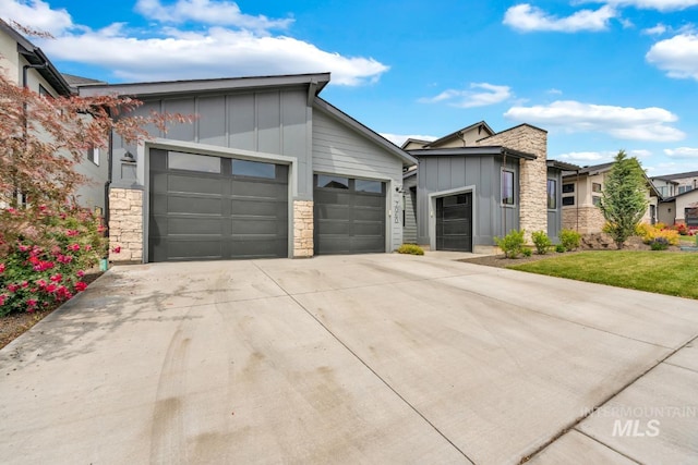 7060 E La Cuesta St, Boise, ID 83716 - contemporary home with board and batten siding, stone siding, driveway, and a garage