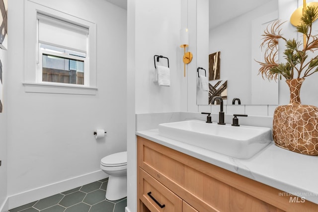 7060 E La Cuesta St, Boise, ID 83716 - bathroom featuring vanity, toilet, baseboards, and tile patterned floors