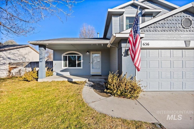 view of front property featuring a garage, covered porch, and a front yard