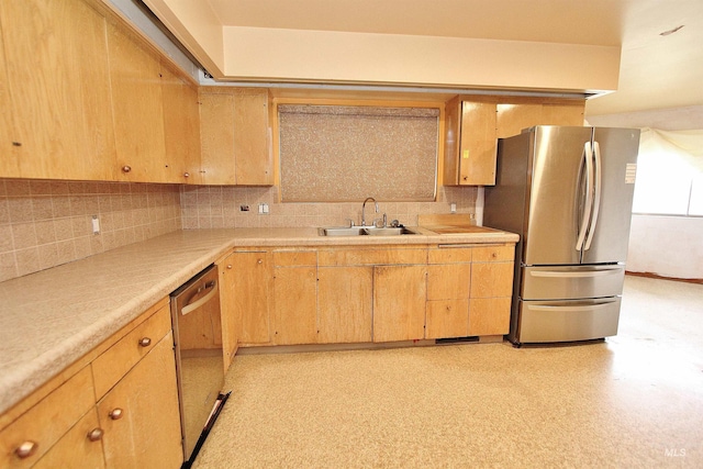 kitchen with a sink, light countertops, appliances with stainless steel finishes, backsplash, and light floors