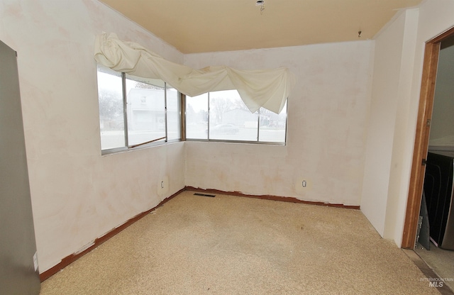 carpeted empty room featuring visible vents