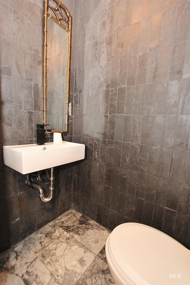 half bath featuring tile walls