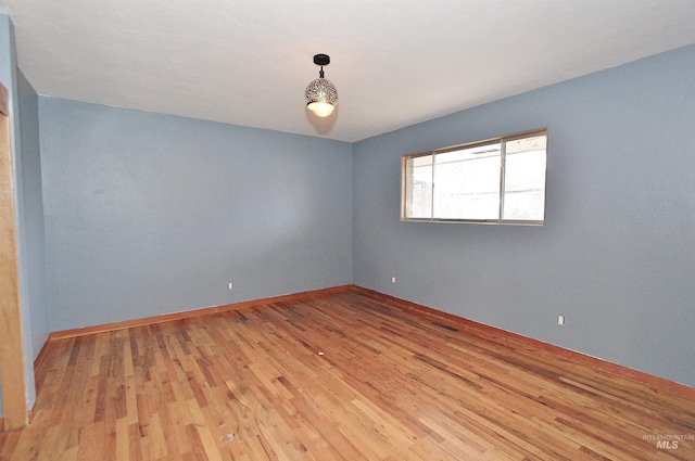 empty room with light wood-type flooring and baseboards