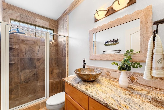 bathroom with toilet, an enclosed shower, and vanity