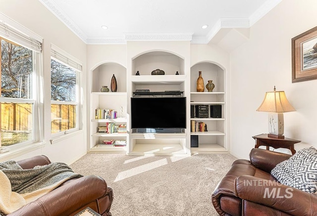 living room with carpet flooring, a wealth of natural light, built in shelves, and crown molding