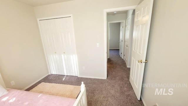 unfurnished bedroom featuring carpet floors, a closet, and baseboards