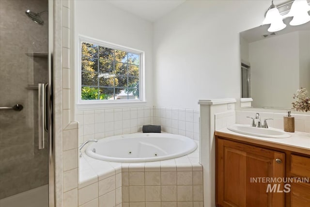 bathroom featuring a shower stall, a jetted tub, and vanity