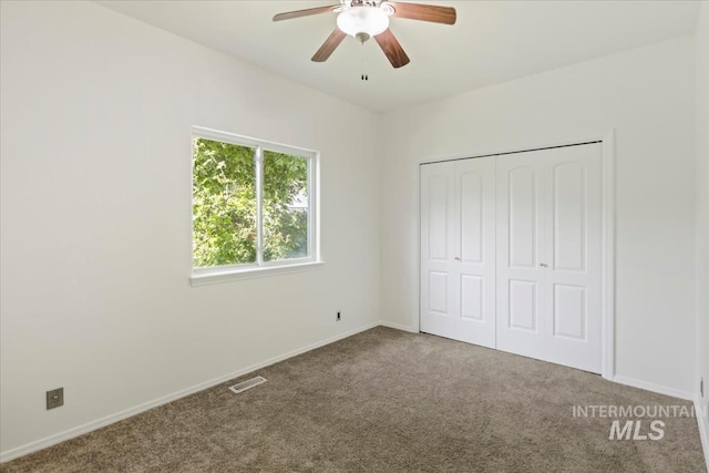 unfurnished bedroom with carpet floors, baseboards, a closet, and ceiling fan