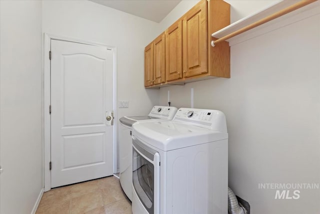 washroom with washing machine and clothes dryer, cabinet space, and baseboards