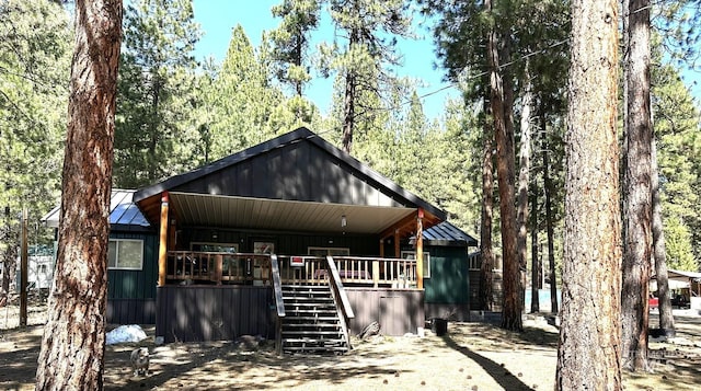 rustic home featuring stairs, a porch, a standing seam roof, and metal roof