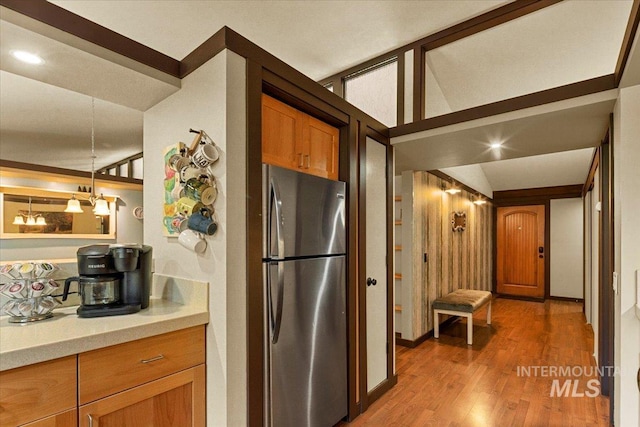 kitchen with light wood-style floors, light countertops, brown cabinetry, freestanding refrigerator, and recessed lighting