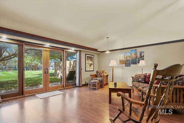 sitting room with french doors, vaulted ceiling, wood finished floors, and visible vents