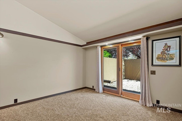 empty room with baseboards, lofted ceiling, and light carpet