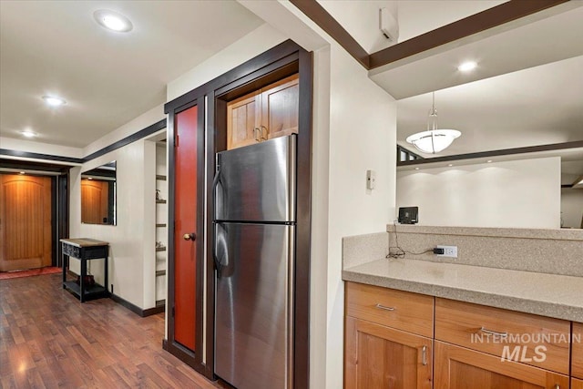 kitchen with brown cabinets, hanging light fixtures, dark wood finished floors, freestanding refrigerator, and recessed lighting