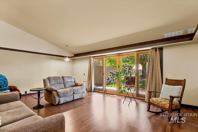 living area featuring baseboards, visible vents, wood finished floors, and lofted ceiling