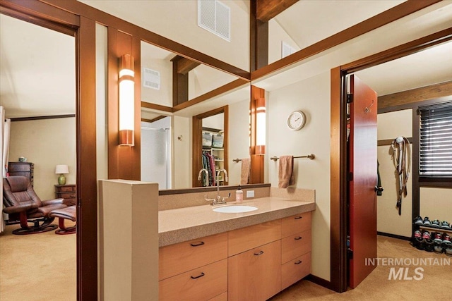 bathroom featuring beamed ceiling, visible vents, and vanity
