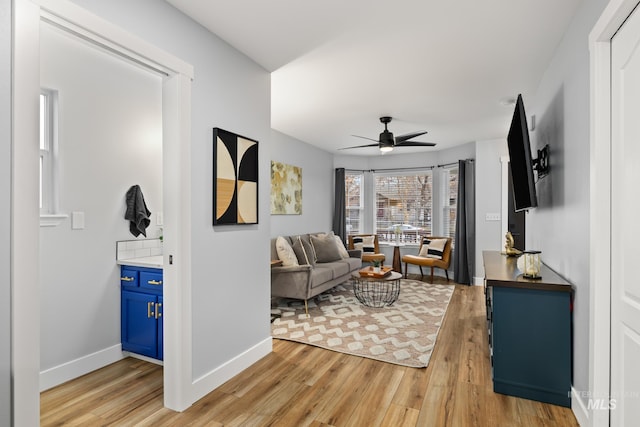 living room with ceiling fan and light hardwood / wood-style flooring