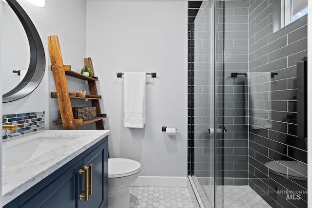 bathroom featuring tile patterned flooring, vanity, toilet, and a shower with shower door