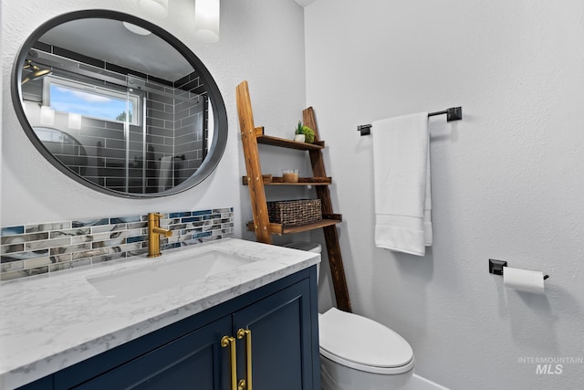 bathroom featuring tasteful backsplash, vanity, and toilet