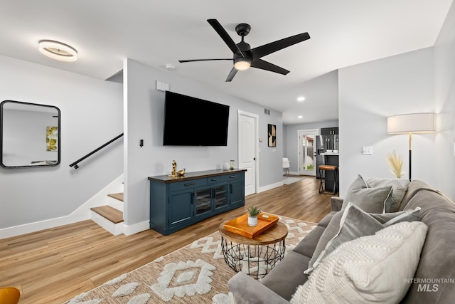 living room with light hardwood / wood-style floors and ceiling fan