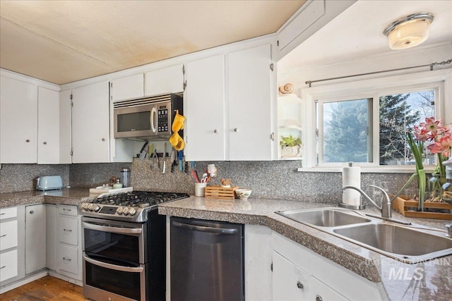 kitchen with tasteful backsplash, white cabinets, stainless steel appliances, and a sink