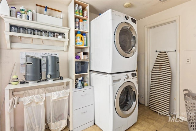 laundry room featuring laundry area, stacked washer / dryer, and light floors