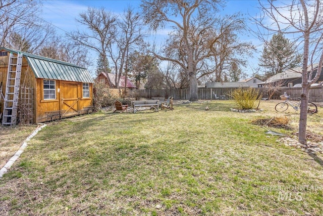 view of yard featuring an outdoor structure, a storage unit, and a fenced backyard