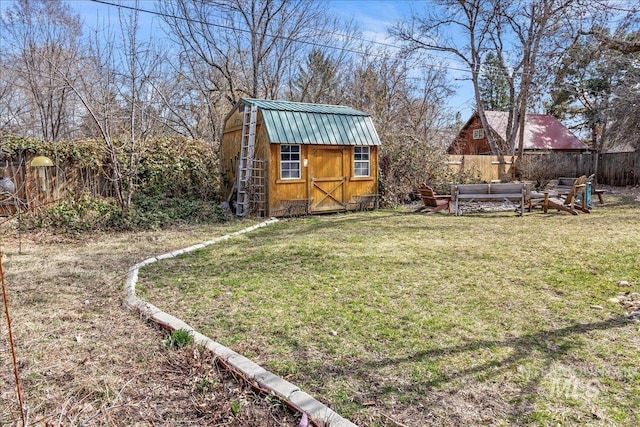 view of yard with a storage unit, an outbuilding, a fenced backyard, and outdoor lounge area