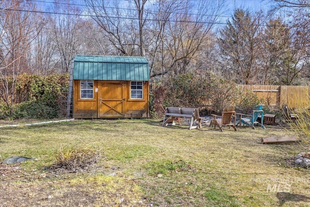 view of yard with a storage unit, an outdoor structure, and fence