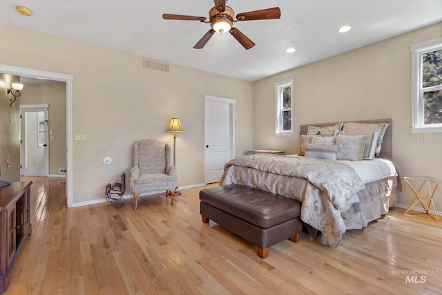 bedroom with light wood-style floors, baseboards, multiple windows, and visible vents