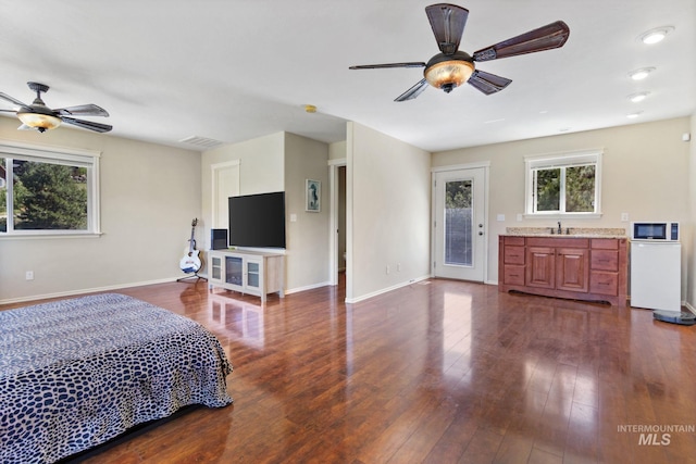 bedroom featuring dark wood-type flooring, a sink, and baseboards