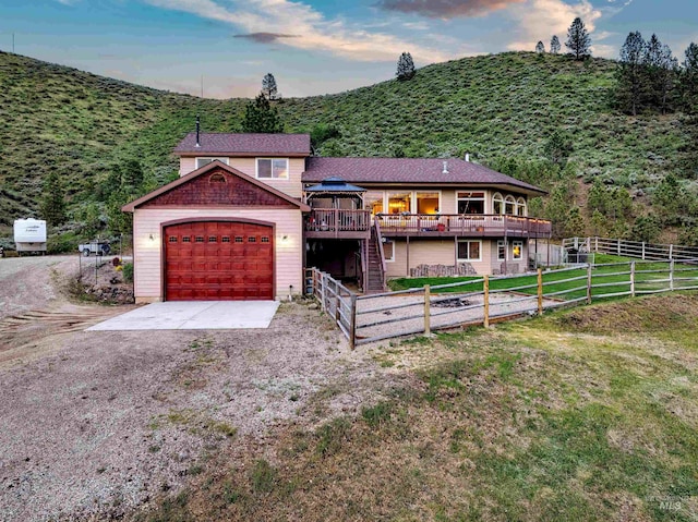 view of front of property with a deck, a garage, fence, driveway, and stairway