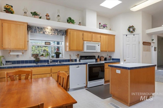 321 S 600 E, Jerome, ID 83338 - kitchen with white appliances, a sink, tile counters, a center island, and light flooring