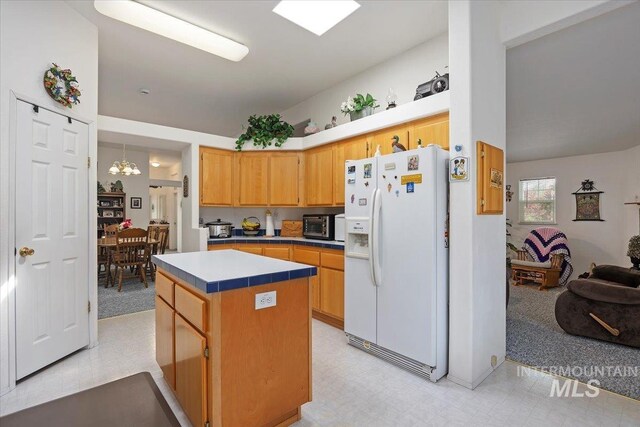 321 S 600 E, Jerome, ID 83338 - kitchen with white refrigerator with ice dispenser, a kitchen island, a chandelier, and light floors