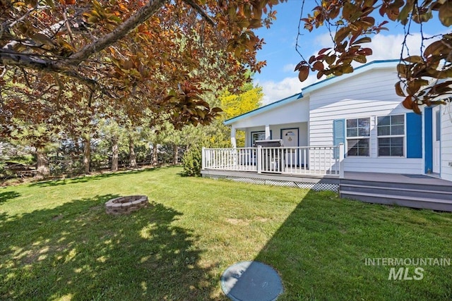 321 S 600 E, Jerome, ID 83338 - view of grassy yard featuring a fire pit and a deck