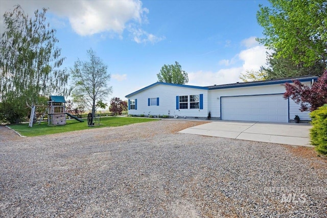 321 S 600 E, Jerome, ID 83338 - view of front facade with concrete driveway, a garage, a front yard, and a playground