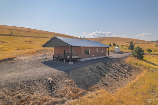 back of property featuring crawl space, a rural view, and metal roof