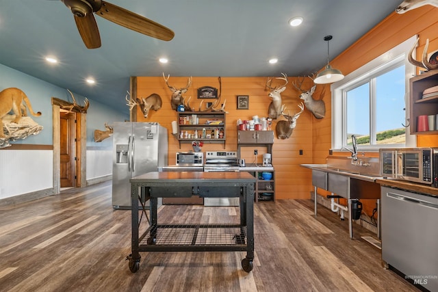 rec room with dark wood finished floors, baseboards, recessed lighting, wood walls, and ceiling fan