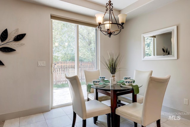 dining space with an inviting chandelier, light tile patterned floors, and baseboards